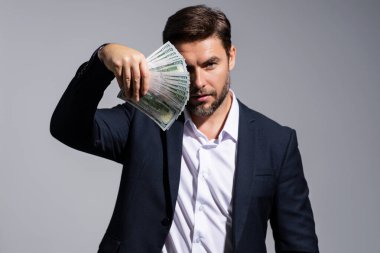 Dolar banknotları olan bir adam. Bir sürü 100 dolarlık banknot tutan bir iş adamı. Kolay para. Kara para. Ödeme günü ve ödeme konsepti. Kâr ve zenginlik. Para kazan. İş adamı başarılı anlaşma