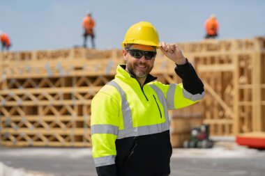 İnşaat işçisi inşaat halinde. İnşaat geçmişinde inşaat üniforması var. İnşaat alanındaki inşaatçı. Kasklı Amerikalı işçi. Bilder in hardhat