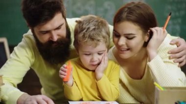 Sevimli zeki çocuk çalışması. Mutlu aile çizim kitabı. Anne baba ve oğul kitap ev ödevini okuyorlar. Anne ve babalar, çocuk sahibi olmaktan gurur duyuyor.