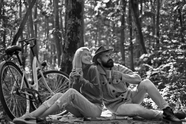 Romantic couple on date. Date and love. Autumn date hike in forest. Romantic date with bicycle. Couple in love ride bicycle together in forest park. Bearded man and woman relaxing in autumn forest.
