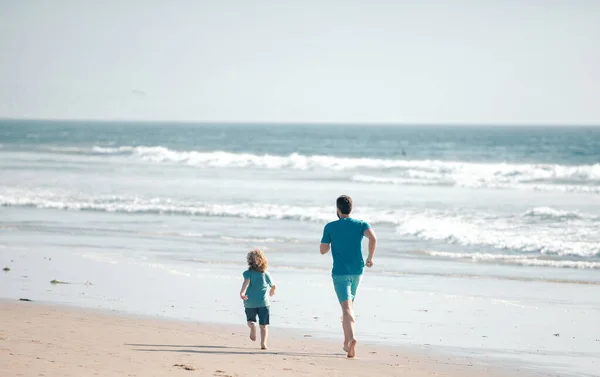 父と息子は海を走っている 父と子供は屋外で楽しんでいます 家族旅行 父の日の概念 — ストック写真