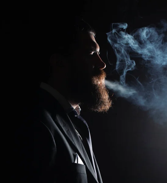 在黑色背景上吸烟 穿西装抽烟的商人 — 图库照片