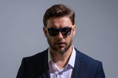 Gri stüdyodaki iş adamı izole edilmiş. Takım elbiseli zengin adam, stüdyo portresi. Başarılı bir iş adamı. Finansal başarı. İş adamı başarılı anlaşma