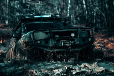 Yol araç kapalı dört tekerlekten sürücü için seyahat ve yarış konsepti. Ormandaki tekerleklerin arasından kar ve çamura giren tekerleklerin lastikleri ve off-road kamyon şaftının ayrıntılı görünümü