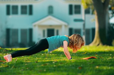Çocuk şınav çekiyor. Jimnastik. Çocuk sporcusu, çocukluk aktivitesi. Çocuklar spor ve spor yapar. Çocuk itiyor