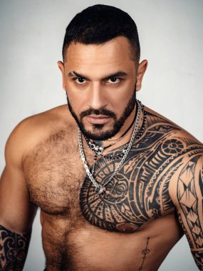 Seksi dövmeli adam. Erkek modası. Atletik vücudu olan kaslı maço bir adam. Kendine güven karizması. Spor sağlık sigortası. Vahşi sporcu gövdesi. Steroitler. Spor başarısı. Sağlıklı yaşam tarzında başarı.