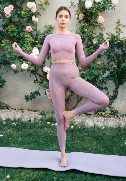 健身女运动员在训练前伸展身体 Yogi女人练习瑜伽 Vrksasana练习 伸展和动机 户外运动 — 图库照片