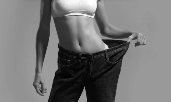 大きなパンツで薄い女性は 減量の概念 特大の大きなズボンを着たスリムな女の子 女性の体重減少 ダイエット後のスリムな体を持つ女性 — ストック写真