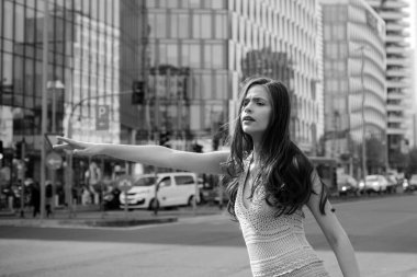 Genç iş kadını taksi çağırıyor. İş kadını şehir caddesinde taksi yakalıyor. Başarılı ve kendinden emin.