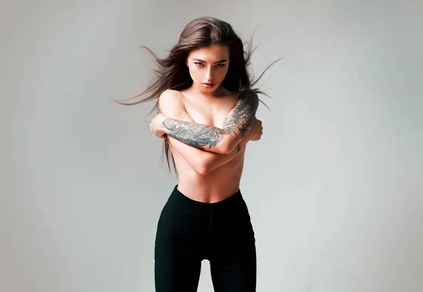Tall slim lady. Tattooed sensual model long hair. Fashion concept. Windy hairstyle. Girl attractive fashion model. Vogue and fashion. Gorgeous pretty woman. Topless model wear high waist pants.