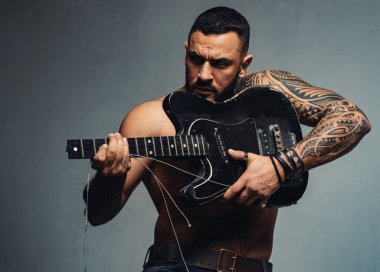 Silah olarak gitar. Kırık gitar çalan vahşi Latin adam. İspanyol gitarist elektro gitarist ile müzik çalıyor. Güçlü ellerde gitar çalan sakallı gitarist, boşluğu kopyala.