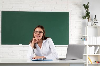 Okulda internetten öğrenme, uzaktan eğitim. Üniversitede ya da lisede dizüstü bilgisayarı olan çekici genç kız öğrencinin portresi