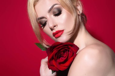 Sıska, seksi, çıplak omuzlu, kırmızı güller tutan, stüdyo arka planında soyutlanmış bir kadın. Çiçekli şehvetli bir kızın portresi
