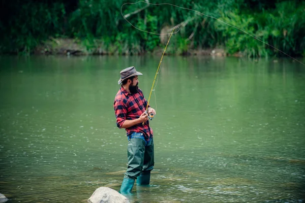 渔夫在山河里用钓竿钓鱼 一个放飞的渔夫在森林里的河里钓野生鳟鱼 — 图库照片