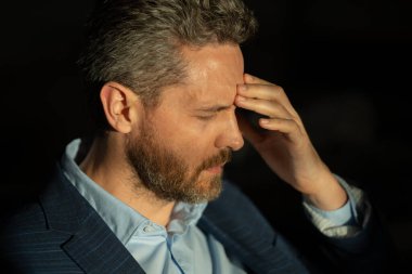 Baş ağrısı, yorgunluk ve stres. Takım elbiseli adamın yakın plan portresi baş ağrısı yapıyor. Baş ağrısı konsepti. Ofiste acılı adamlar streslidir. Stresli ve baş ağrısı