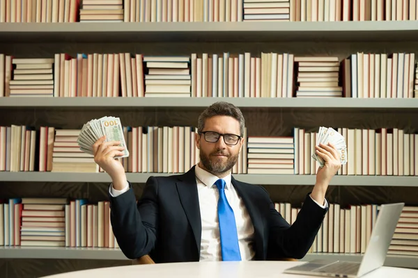 Man holding cash money in dollar banknotes in office. Studio portrait of businessman with bunch of dollar banknotes. Dollar money concept. Career wealth business. Cash dollar banner