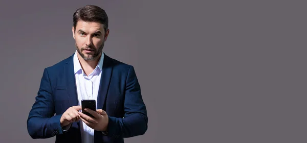 Business man in suit watching on mobile phone. Handsome man using smart phone, type sms message. Social network. Banner for header, copy space. Poster for web design