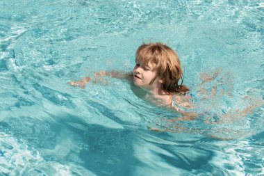 Havuzdaki mutlu çocuk. Havuz tatili. Yaz haftasonu. Aquapark 'ta gülümseyen çocuk. Çocuk suda yüzüyor.