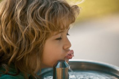 Parktaki bir çeşmeden su içen çocuk