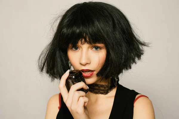 Artificial hair. Hairdresser and hairstyle. Lady in black wig with make up. Hair care and styling. Barber salon. Woman with red lips mysterious person. Girl dreamy face wear fashion brunette wig.