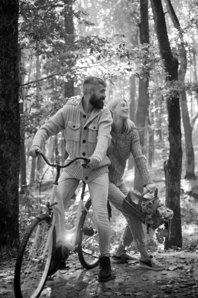 秋の森で自転車に乗るのが大好きです 日当たりの良いセーターの天気と良い波 秋の公園での恋人たちのサイクリング黄色の葉の背景 幸せな妻と夫 — ストック写真