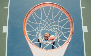 Basketbol oynayan çocuk. Neşeli çocuk basketbol oyuncusu elinde top tutuyor.