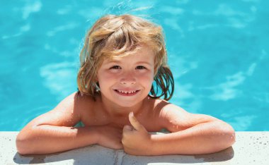 Havuzdaki çocuk. Yüzme havuzunun mavi suyunda baş parmağını kaldırmış şirin bir çocuk. Eğlence için yaz tatili. Başlık için afiş, kopyalama alanı. Web tasarımı için poster