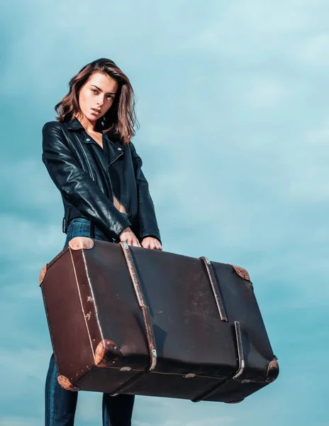 Sexy young beautiful woman with luggage wearing a leather jacket