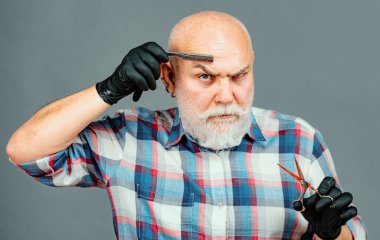 Kıdemli berber. Sakallı adam, sakallı erkek. Beyaz sakallı şık berber portresi. Berber makası ve ustura, berber dükkanı. Klasik berber, tıraş.