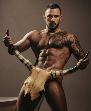 sport and fitness, health. brutal sportsman hold animal skull. steroids. muscular macho man with athletic body. sexy abs of tattoo man. male fashion. confidence charisma. nude male body. seduction. clipart