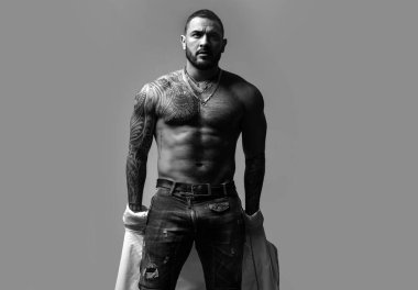 Seksi erkek soyunma gömleği. Seksi bir adamın baştan çıkarıcı yüzü. Maço kendinden emin görünüyor. Çıplak erkek omuzları, üstsüz atletik vücudu.