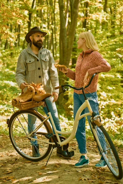 Autumn date hike in forest. Couple in love ride bicycle together in forest park. Romantic date with bicycle. Bearded man and woman relaxing in autumn forest. Romantic couple on date. Date and love.