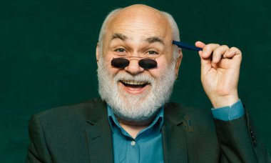 Karatahta masasının yanındaki sınıfta dost canlısı bir öğretmen. Eğitim ve öğrenim insanları kavramı - kadın öğretmen tahtaya yakın. Öğretmenler günü. Teşekkürler öğretmenim.