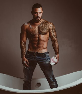 Çıplak vücutlu, küvette yıkanan seksi adam. Erkek model banyoda baştan çıkarıcı, vahşi banyo, çıplak gövde.