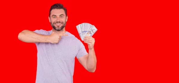 stock image Portrait business man holding cash dollar bills over red studio background. Big luck, banner. Dollar cash money concept. Rejoices to win cash. Man hold cash money. Financial luck and success