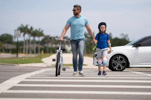 Safety on road. Pedestrian crossing for cyclists. Father and son ride a bicycle. Father support and helping son. Fathers day concept. Father and son friends. Child care