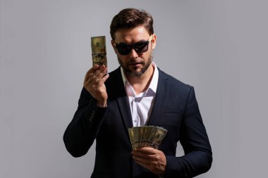 Para banknotları olan bir iş adamı. Dolar banknotları olan bir erkek girişimci. Şanslı patron, sigortacı, menajer. Parası olan serbest çalışan biri. Kopyalama alanı olan beyaz pankart için