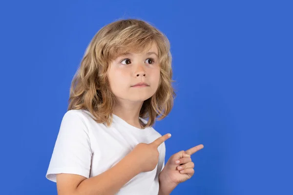 Dziecko Odwraca Wzrok Wskazując Palcem Niebieskie Odizolowane Tło Studia Chłopiec — Zdjęcie stockowe