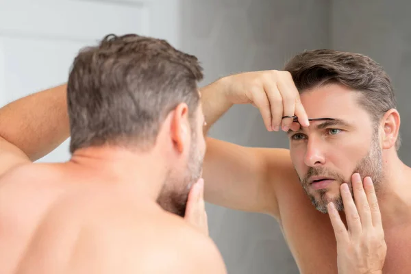 美容師が化粧品クリームを顔に塗る 顔の治療 顔クリームを適用男の美しさの肖像画 スキンケア製品 しわのある男の顔の皮膚のための保湿クリーム 完璧な肌の男 — ストック写真