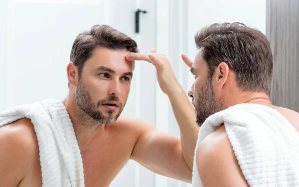 有魅力的男人 刮胡子后能完美地触摸面部肌肤 护肤保健化妆品程序的概念 近视男子镜面 皮肤敏感 美容外科治疗 皮肤护理 — 图库照片