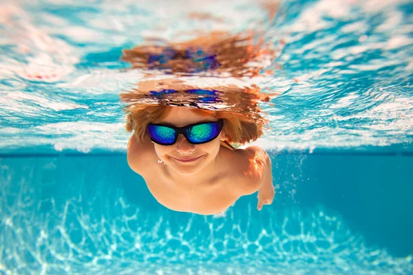 プールで泳いでいる子供 面白い男の子はプールで水中で泳ぐ 水中の子供たちは水中から肖像画を描く 夏休みだ 子供の週末 — ストック写真