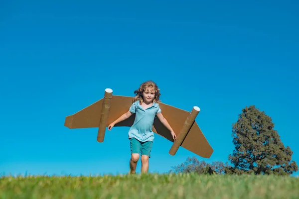 stock image Child boy playing with cardboard toy airplane wings craft in sky with copy space for text. Creative with family and dreaming of flying concept