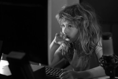 Bilgisayar oyunu oynayan ya da bilgisayar başında okuyan bir çocuk. Gece lambası kullanan çocuk oyuncu. Evde bilgisayar teknolojisi kullanan bir çocuk