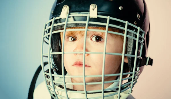 Boy cute child wear hockey helmet close up. Safety and protection. Protective grid on face. Sport equipment. Hockey or rugby helmet. Sport childhood. Future sport star. Sport upbringing and career.