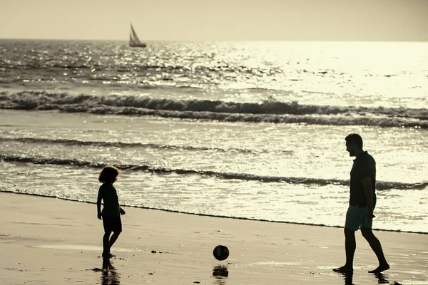 父と息子はビーチでサッカーやサッカーをします 家族旅行 父の日の概念 屋外で遊んでいる父と子供 — ストック写真