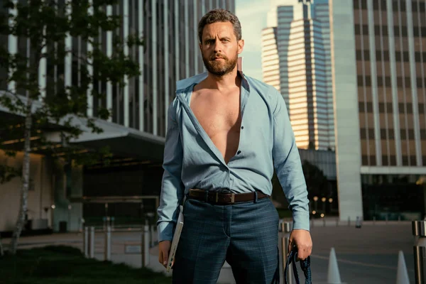 Attractive man in open shirt. Sexy businessman outdoors. Attractive man taking off shirt. Confident in his appealing. Handsome man fashion model