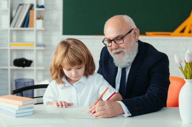 Okuldaki mutlu çocuk. Öğretmenin öğrenmesine yardım et. Eğitim, öğretmenlik, ilkokul.