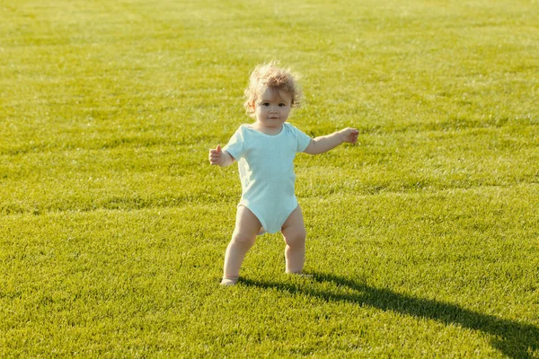赤ん坊は緑の芝生の上で裸足で立っている 健康な子供 — ストック写真