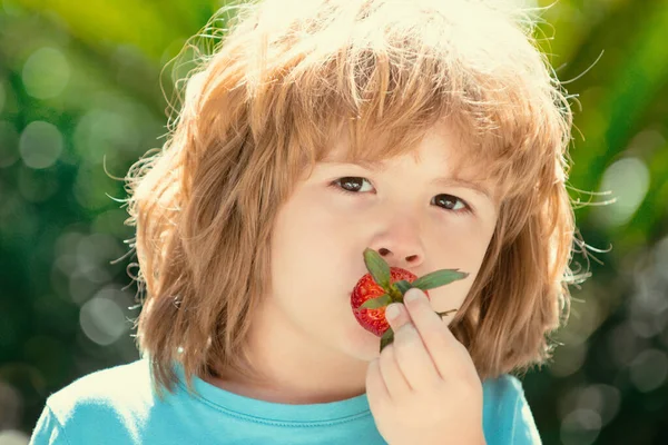 Niño Comiendo Fresas Sobre Fondo Verde Primavera — Foto de Stock