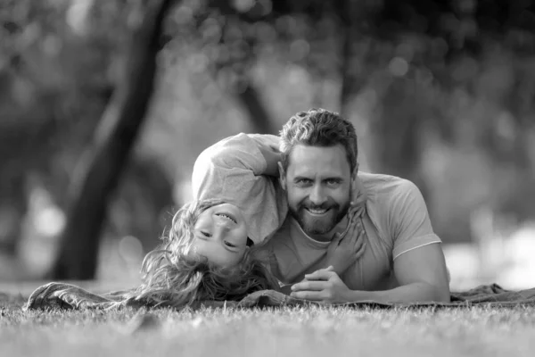 父子俩躺在自然公园的草地上 人们在户外玩得很开心快乐假期和友善家庭的概念 — 图库照片